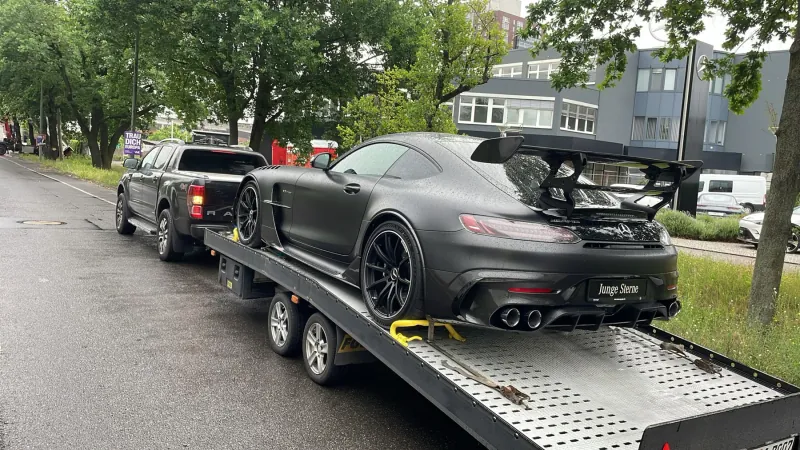 Schwarzer Mercedes-AMG GT mit Heckflügel auf der Transportplattform