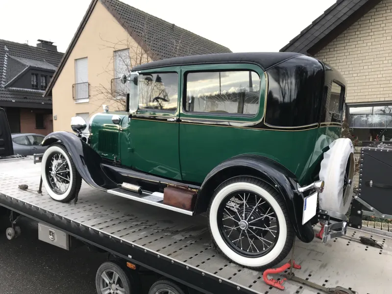 Grüner Oldtimer mit Weißwandreifen auf einem Anhänger